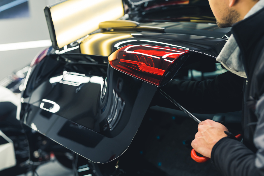 Technician removing dent from vehicle