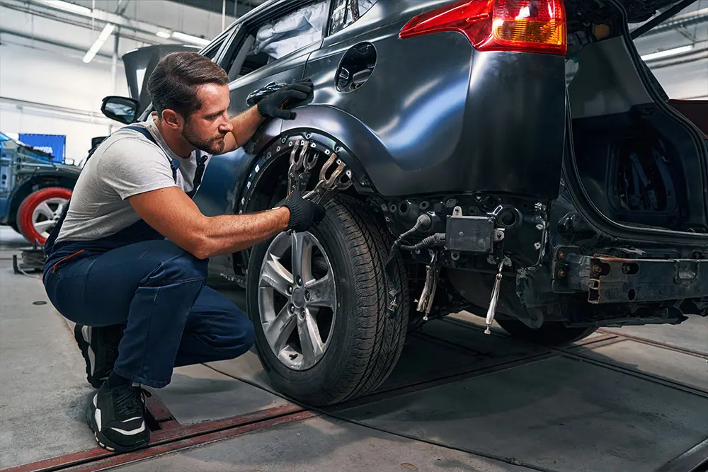 Technician working on car frame repair